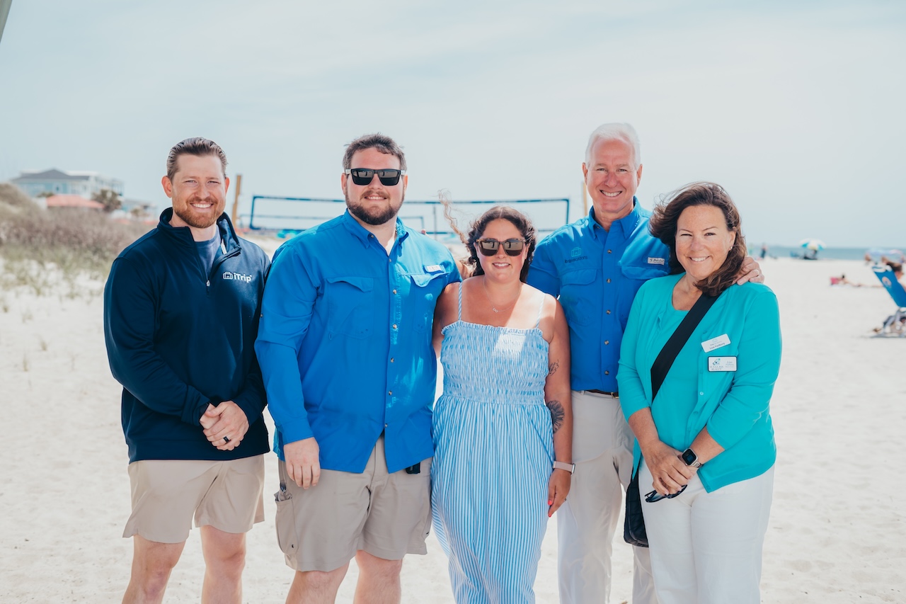 Photo of iTrip Oak Island property management team on a beach